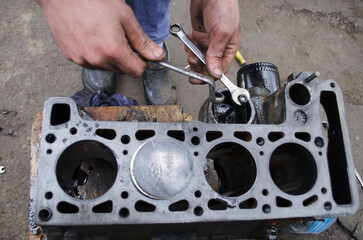 An auto mechanic is working on a car engine in a mechanics garage. Repair service. authentic close-up shot. VAZ 2106