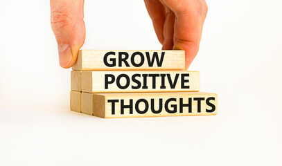 Grow positive thoughts symbol. Concept words Grow positive thoughts on blocks. Businessman hand....