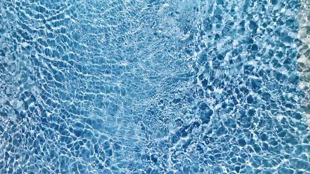 Water surface texture, Slow motion looping clean swimming pool ripples and wave, Refraction of sunlight top view texture sea side white sand, sun shine water loop background