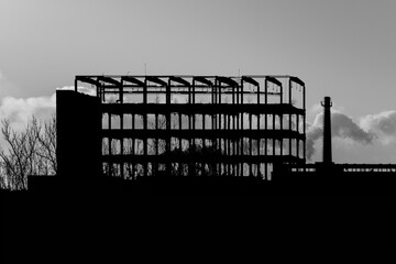 Completely destroyed external walls of the production building of a large industrial plant.