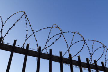 Fencing of a large industrial plant in the form of a fence with barbed wire.