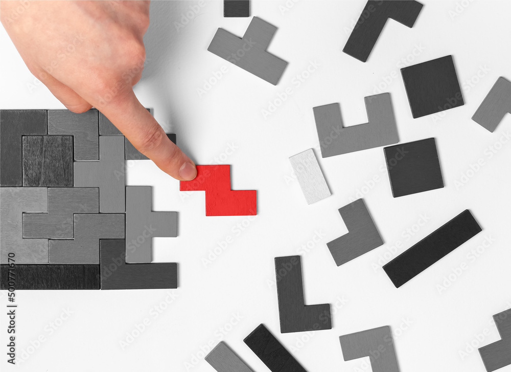 Poster hand putting outstanding tetris puzzle piece. logical thinking, problem solving concept. important m