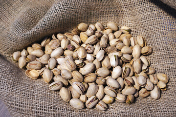 Pistachios on burlap sack. Organic pistachios. Vegan Healthy food high protein. Dietary nutrition. Concept of nuts.
