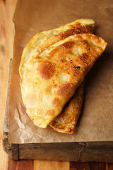 Homemade juicy golden deepfried turnovers chebureks on baking paper. Traditional Turkic-Mongolian dish. Street food