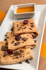 Delicious pancakes with honey, chocolate and cherries.
