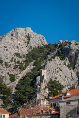Fototapeta na wymiar View of the fortress tower above the rooftops in the old town of Omis, Croatia