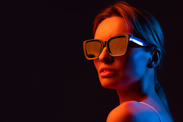 young woman adjusting sunglasses and posing isolated on purple