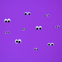 Eyes on a purple background. Flat lay concept.