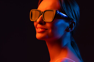 young woman adjusting sunglasses and posing isolated on purple
