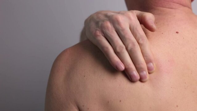 Shoulder pain and trigger points. Man close up massaging painful body part.