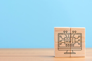 Wooden cubes on blue background with icon of software app application development api, concept