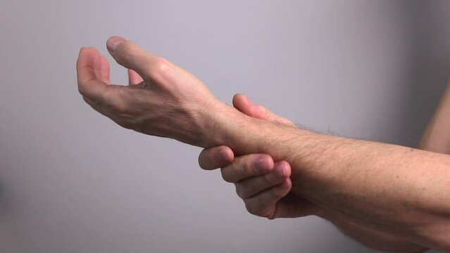 Man suffering from wrist pain and holding painful hand closeup. Hand injury. Health care, medicine concept.