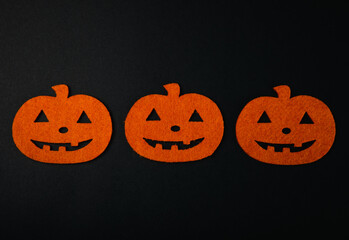 Composition of figures of orange pumpkins and bats on a black background. DIY Halloween decor.Holiday card.Halloween holiday concept.Copy space.Top view.Pattern