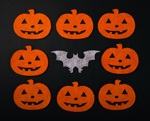 Frame of figures of orange pumpkins and bats on a black background. DIY Halloween decor.Holiday card.Halloween holiday concept.Place for copy.Place for text.Top view.