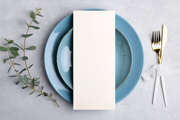 Vertical menu card mockup with festive wedding or birthday table setting with golden cutlery, eucalyptus, blue ceramic plate on grey background. Restaurant menu concept. Flat lay, top view - obrazy, fototapety, plakaty