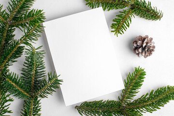 Fototapeta na wymiar Christmas 5x7 card mockup template with fir twigs on white background. Design element for Christmas and New Year congratulation, rsvp, thank you, greeting or invitation card