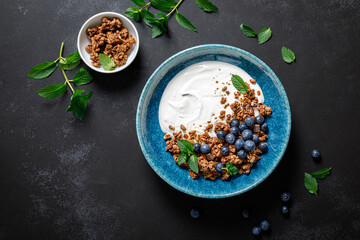 Chocolate granola with white plain yogurt and fresh blueberry in a bowl, healthy food for...