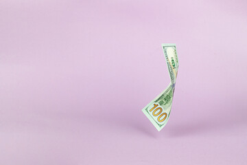 Flying of US dollar banknote on pink pastel background. Investment and saving concept.