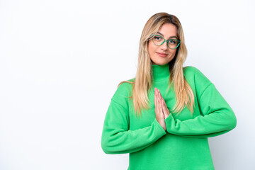 Young Uruguayan woman isolated on white background keeps palm together. Person asks for something