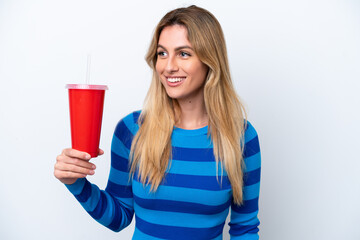 Young Uruguayan woman drinking soda isolated on white background looking side