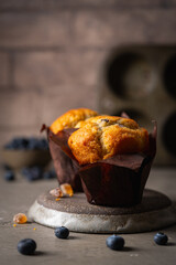 Sweet homemade pastries muffin with blueberries and fresh berries on stone background.