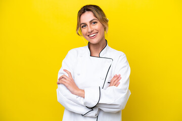 Uruguayan chef woman isolated on yellow background keeping the arms crossed in frontal position