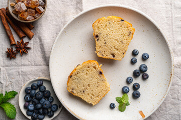 Sweet homemade pastries cutting muffin with blueberries and fresh berries on white background, top view.