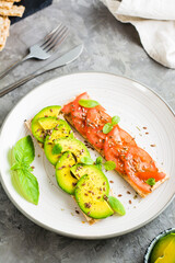 Appetizing bruschetta with avocado and tomatoes on grain bread on a plate. Vertical view. Close-up