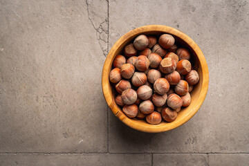 hazelnut nuts in a bowl on gray stone background top view with copy space. Healthy snack food.