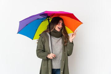 Young caucasian woman holding an umbrella isolated on white background intending to realizes the solution while lifting a finger up
