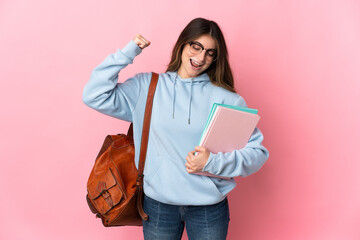 Young student woman isolated on pink background doing strong gesture
