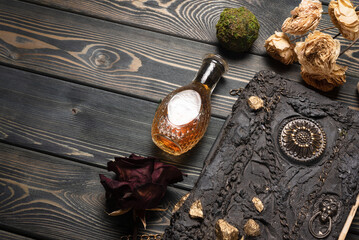 Book of magic and magic potion on the wooden table background. Witchcraft concept.