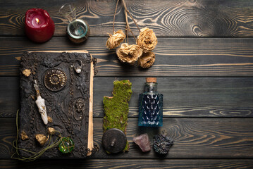 Book of magic and magic potion on the wooden table background. Witchcraft concept.