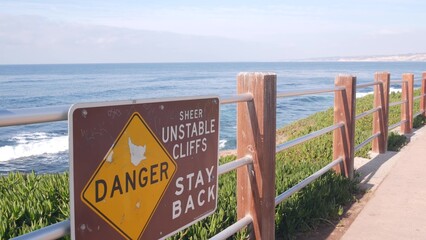 Ocean waves crashing on beach or bluff, La Jolla shore waterfront promenade, California USA....