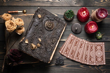 Tarot cards and book of magic on the wooden table background.