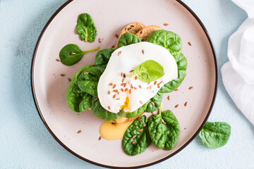 Appetizing sandwich with poached egg and spinach on a plate. Flexetarian Diet. Top view. Close-up