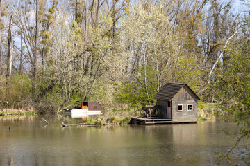 Obraz premium Small wooden house in the forrest, on the river.
