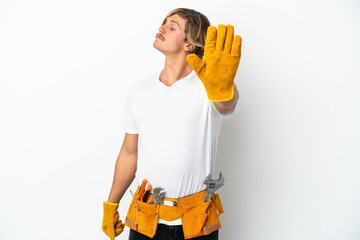 Young electrician blonde man isolated on white background making stop gesture and disappointed