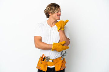 Young electrician blonde man isolated on white background pointing to the side to present a product