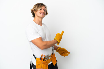 Young electrician blonde man isolated on white background pointing back