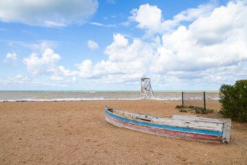 Old wooden boat lays upside down on Black sea coast, landscape photo