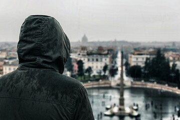 Encapuchado viendo Roma bajo la lluvia
