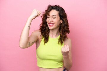 Young caucasian woman isolated on pink background celebrating a victory