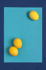 Yellow Easter eggs on a blue background. Top view.