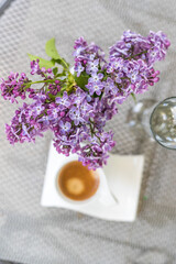 Obraz na płótnie Canvas Purple lilac flowers and a cup of coffee.Morninig, spring