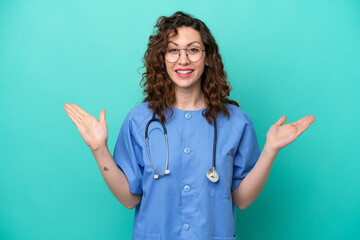 Young nurse caucasian woman isolated on blue background with shocked facial expression