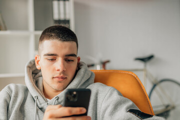 young teenager at home looking at mobile phone