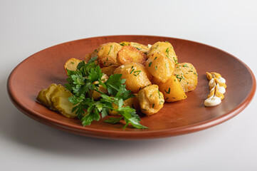 Fried potatoes on a peasant on a brown clay plate, home, restaurant cuisine, dishes isolated on a...