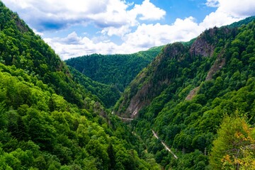 Beautiful landscape of high green mountains and a gorge along which one of the most beautiful roads in the world, Transfagarasan. Romania.