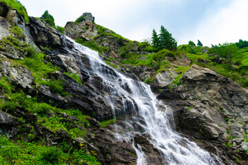 The Balea waterfall flow down the stone slope of the mountain. Waterfall location near...